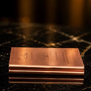 May include: A rectangular one kilogram copper bar with a metallic finish. The surface is engraved with the chemical symbol Cu, atomic number 29, atomic weight 63.546, a tree illustration, the text Made in India, and 99.9% Fine Copper.