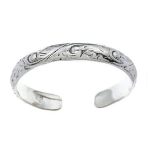 May include: A silver toe ring with a delicate floral design.