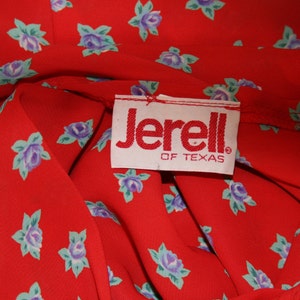 May include: Red fabric with a white label that says "Jerell of Texas". The fabric has a small blue and green floral pattern.