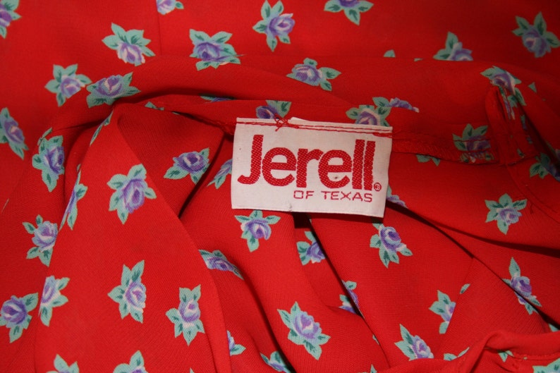 May include: Red fabric with a white label that says "Jerell of Texas". The fabric has a small blue and green floral pattern.