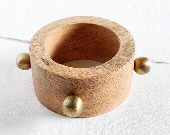 Brazalete grueso de madera de huerto con detalle de cuentas de latón