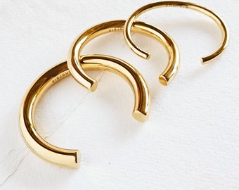 May include: Three gold-toned metal bangles with the word "BISJOUX" engraved on one of the bangles.