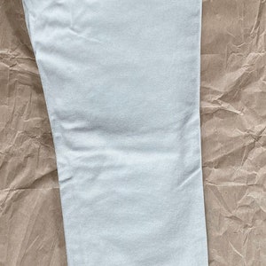 May include: A pair of light-colored jeans with a Levi's tag that says "slim fit 512 straight leg".