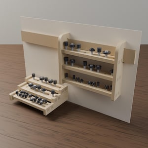 Könnte beinhalten: Ein Aufbewahrungssystem aus hellem Holz mit einer wandmontierten Einheit mit drei horizontalen Regalen und einer separaten, abgestuften Bodeneinheit. Beide Komponenten enthalten zahlreiche dunkelgraue Fräser in vorgebohrten Löchern.
