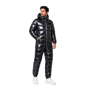 May include: A black, shiny, quilted one-piece jumpsuit featuring a full-length front zip, a hood, and long sleeves. The garment has a high-gloss finish and horizontal baffle construction throughout the torso and legs.