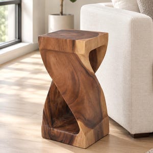 May include: A solid wood side table featuring a natural brown finish with visible grain patterns. The piece has a distinct twisted, hourglass-like silhouette with a square top and base, creating an open, sculptural form made from a single block.