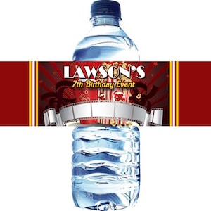 May include: Red and yellow water bottle label with a movie theme. The label features a film reel, popcorn, and the text "LAWSON'S 7th Birthday Event".