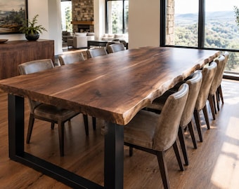 May include: A large rectangular dining table featuring a dark brown natural live edge wood slab top supported by two thick black metal U-shaped legs, accompanied by eight upholstered chairs with light brown seats and dark wooden frames.