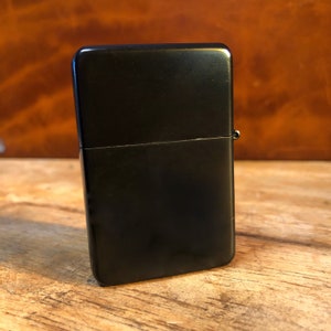 May include: A black metal lighter with a matte finish.