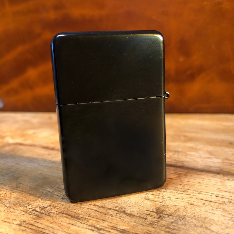 May include: A black metal lighter with a matte finish.
