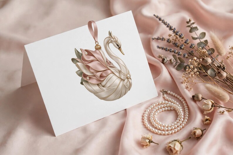 May include: A white greeting card featuring a central illustration of a swan ornament. The swan is crafted with cream and soft pink ribbon layers, accented with small white pearls and a pink ribbon loop at the top for hanging.