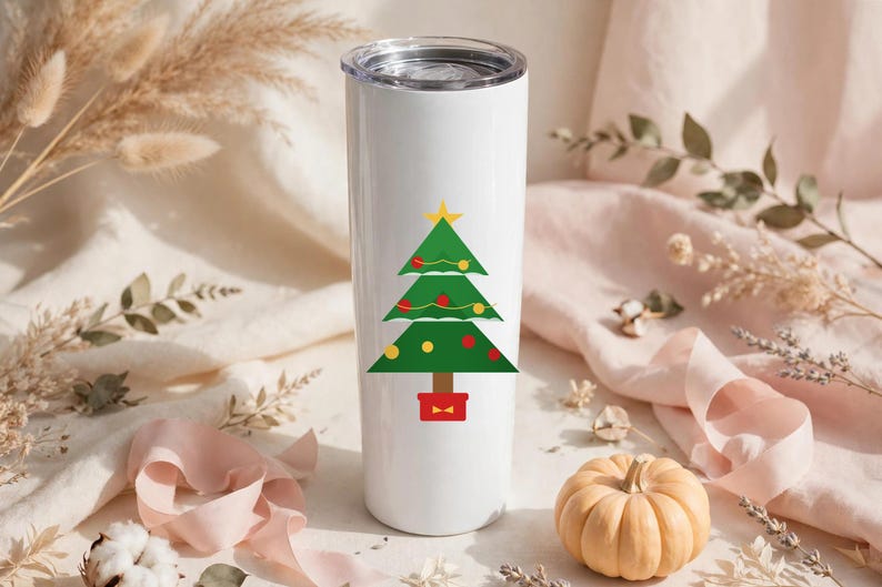 May include: A white cylindrical stainless steel tumbler featuring a graphic of a green Christmas tree decorated with red and yellow ornaments, a yellow star topper, and a brown trunk set inside a red square base with a clear plastic lid.