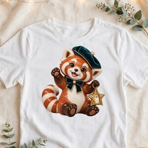 May include: A white t-shirt featuring a graphic of a red panda wearing a dark green beret and a matching bow tie. The red panda is waving one paw and holding a gold star-shaped lantern in the other, with a striped tail curled beside it.