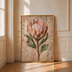 Op de afbeelding: Een ingelijste wandkunstprint met een grote, centrale roze proteabloem op een getextureerde, lichtroze en beige achtergrond. De botanische illustratie toont gedetailleerde bloemblaadjes en groene bladeren in een dunne gouden lijst.