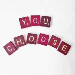 May include: Red and white letter tiles spelling out the phrase "YOU CHOOSE".