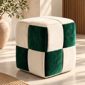 May include: A square ottoman featuring a checkered pattern of alternating cream and dark green velvet fabric panels. The cube-shaped seat has a soft, plush texture with clean, straight seams defining each individual square block.
