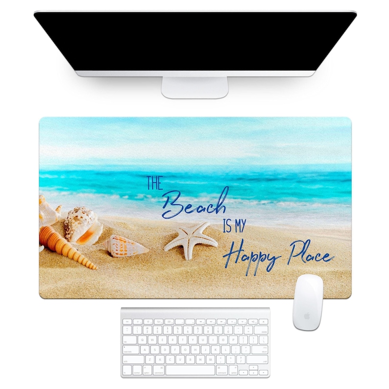 a rectangular desk mat with a beach scene of sand, blue water, and seashells - The Beach is My Happy Place
