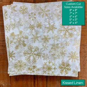 May include: White fabric with a gold snowflake pattern. The image shows custom cut sizes available: 8" x 8", 7" x 7", 6" x 6", 5" x 5", and 4" x 4". The text "Kissed Linen" is also visible.