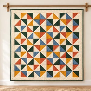 May include: A square quilt featuring a geometric pattern of half-square triangles in mustard yellow, dark green, terracotta orange, and slate blue, set against a cream background with a dark green border, hanging from a wooden rod.