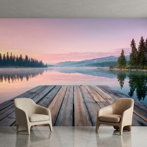 Può includere: Due poltrone imbottite color beige con schienali curvi e gambe in legno sono posizionate su un pavimento liscio davanti a un grande murale che raffigura un molo in legno che si estende in un lago calmo circondato da pini sotto un cielo rosa al tramonto.