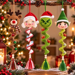 Puede incluir: Cuatro adornos navideños de ganchillo colgantes que representan un reno, una persona con gorro de Papá Noel, una criatura verde con gorro de Papá Noel y un elfo. Cada adorno tiene un cuerpo en espiral, cuentas de madera y una borla colorida.