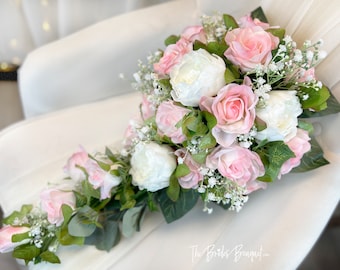 Pode incluir: Um buquê de noiva em cascata com rosas cor-de-rosa e brancas e peônias brancas, adornado com gipsofila e folhagem.