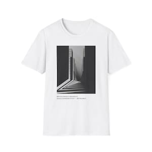 May include: A white short-sleeve t-shirt featuring a black and white rectangular graphic of architectural structures with deep shadows. Below the graphic, the text reads: BRUTALCANVAS // ARCHIVE 01 SCALE & SHADOW STUDY — BÉTON BRUT.
