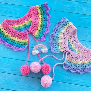 May include: Two rainbow crochet collars with pom poms and a small rainbow crochet charm. The collars are made with a variety of colors, including pink, blue, green, and yellow.