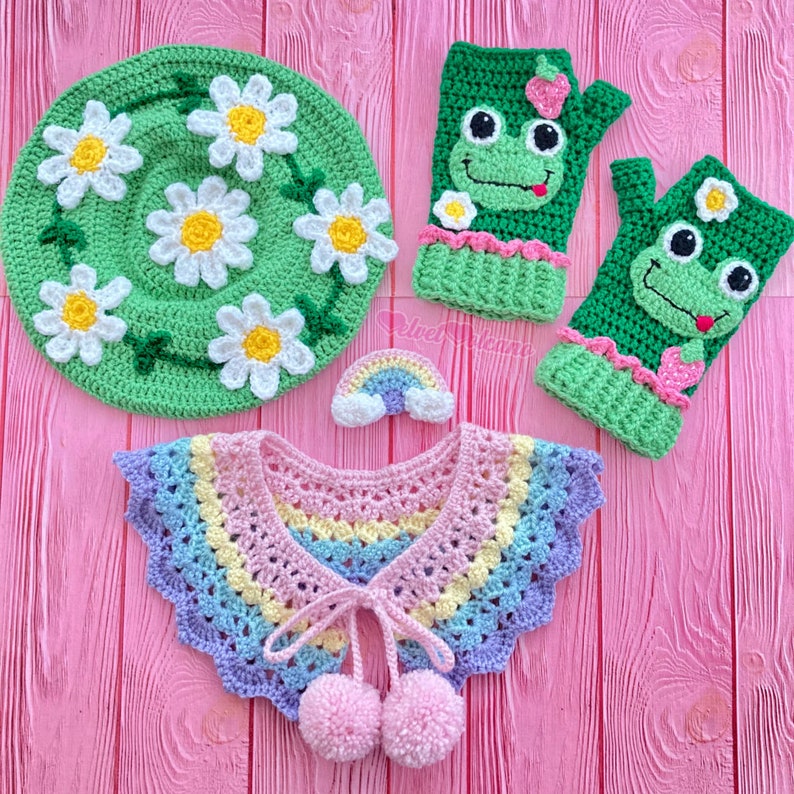 May include: A set of crocheted items including a green daisy hat, a rainbow crochet collar with pom poms, and two green frog finger puppets.