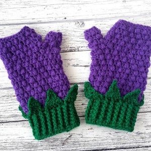 May include: Purple and green fingerless gloves with a textured design. The gloves have a green leaf design at the bottom.