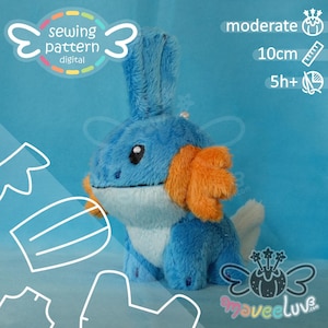 Puede incluir: Una criatura de peluche azul y azul claro con aletas laterales naranjas, una aleta alta en la cabeza y una cola blanca. El patrón de costura digital incluye texto que indica nivel moderado, tamaño de 10cm y 5h+ de tiempo estimado.