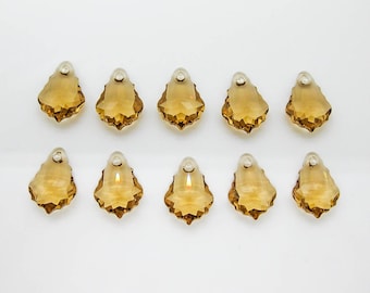 May include: Ten amber crystal teardrop shaped pendants with a faceted design.