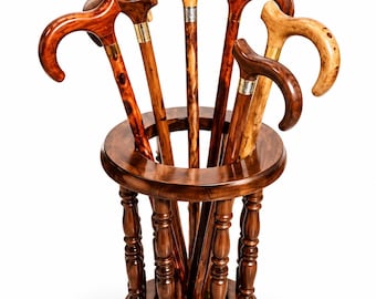 May include: A circular wooden stand holds five walking canes with curved handles. The canes feature various wood grains and metallic collars. The text ThosmoserLTD appears in the upper left corner above the collection of canes.