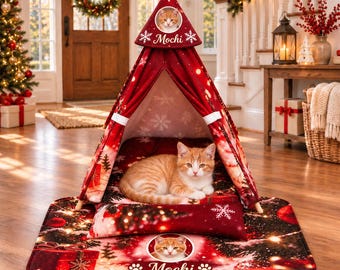 Può includere: Una tenda rossa per animali domestici a tema natalizio con motivi a fiocchi di neve e pacchi regalo. La tenda include una foto circolare di un gatto tigrato arancione e il nome Mochi. Sotto c'è un tappetino abbinato con la stessa foto.