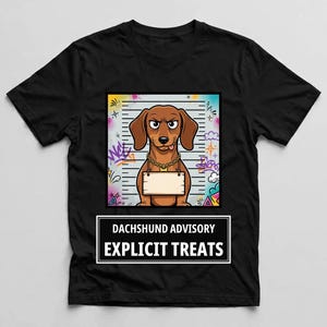 May include: A black t-shirt featuring a graphic of a brown dachshund in a mugshot pose with a gold chain and a blank sign. The background has colorful graffiti elements. Below the graphic, white text reads DACHSHUND ADVISORY EXPLICIT TREATS.