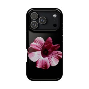 Könnte beinhalten: Eine schwarze Smartphone-Hülle mit einer hochauflösenden Grafik einer leuchtend rosa Blume mit sichtbaren Wassertropfen auf den Blütenblättern. Die Blume ist vor einem einfarbigen schwarzen Hintergrund zentriert, oben sind die Kameralinsen sichtbar.