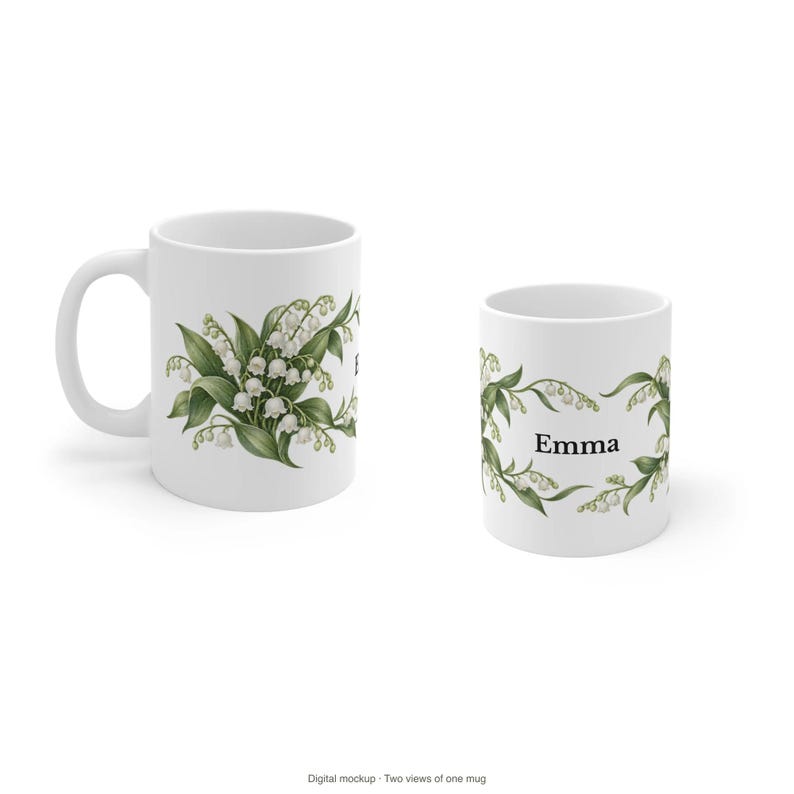 May include: Two white ceramic mugs featuring a botanical illustration of lily of the valley flowers with green leaves. One mug shows the floral design, while the other displays the name Emma in black serif font centered between the floral sprigs.