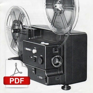 May include: A black and silver 8mm film projector with two clear film reels. The projector has a lens on the front and a control panel with buttons and knobs. The projector is labeled "2500".