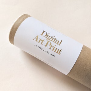 May include: A rolled digital art print in a brown cardboard tube. The white label has gold lettering that reads "Digital Art Print" and the size "A2 (420 x 594 MM)". The print is on a light beige surface.