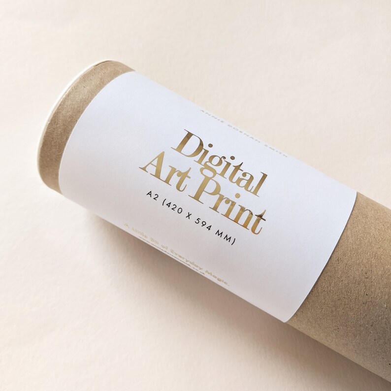 May include: A rolled digital art print in a brown cardboard tube. The white label has gold lettering that reads "Digital Art Print" and the size "A2 (420 x 594 MM)". The print is on a light beige surface.