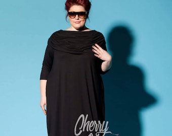 May include: A black maxi dress featuring a draped neckline and three-quarter length sleeves. The dress is worn with sunglasses and leopard print sandals. The text "Cherry Blossoms Dress" is visible on the dress.