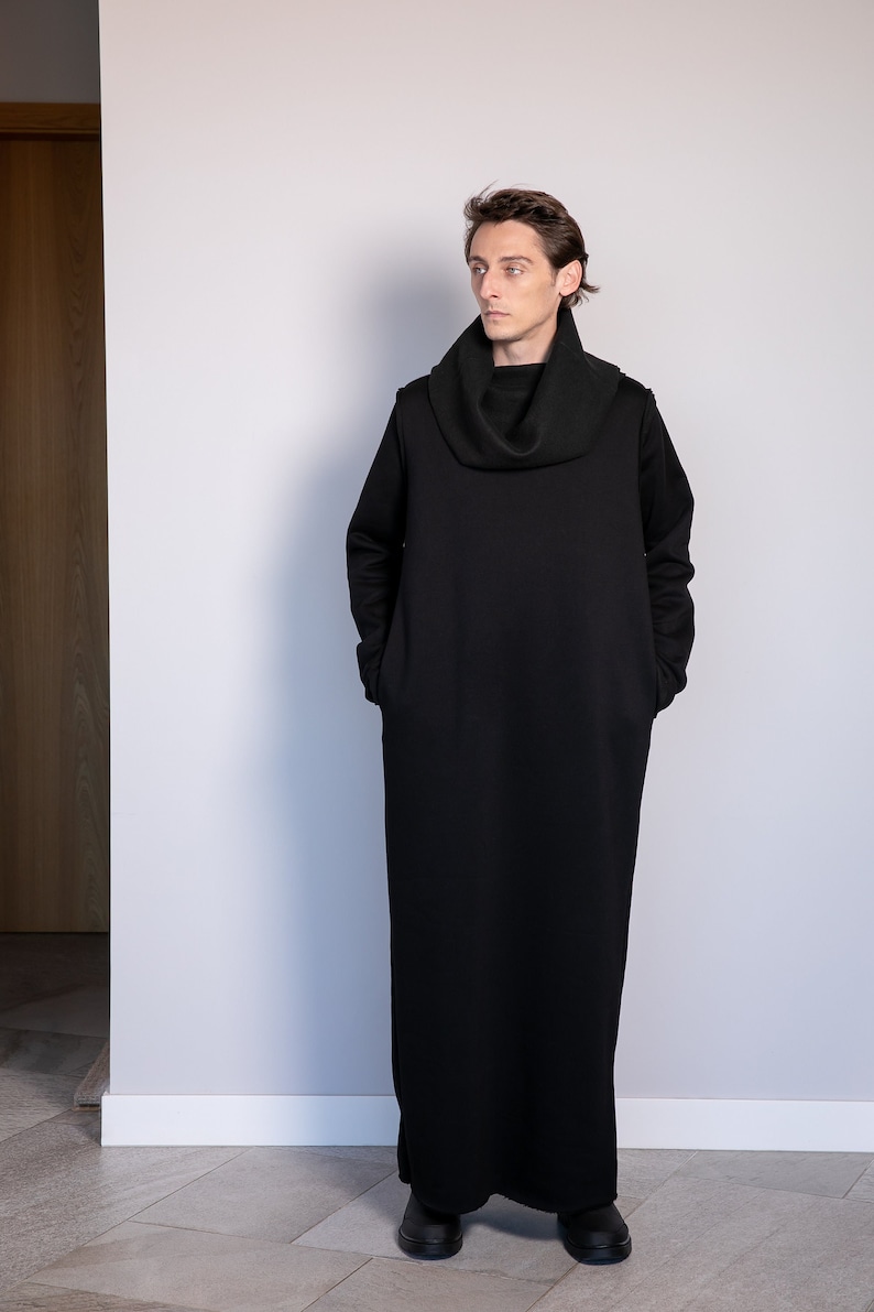 May include: A black long-sleeved tunic with a cowl neck. The tunic has a relaxed fit and is made of a soft, comfortable fabric.