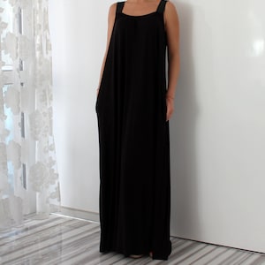 May include: A black maxi dress with thin straps. The dress has a loose, flowy fit and is made of a soft, comfortable fabric.
