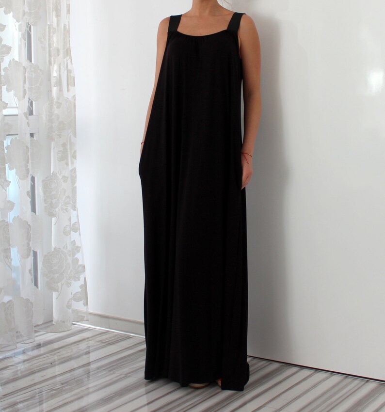 May include: A black maxi dress with thin straps. The dress has a loose, flowy fit and is made of a soft, comfortable fabric.