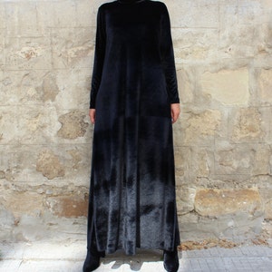 May include: A long black velvet dress with a high neck and long sleeves.