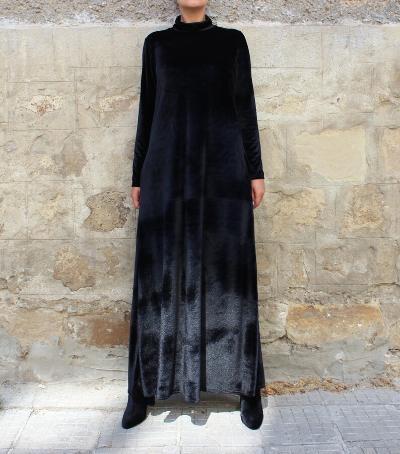 May include: A long black velvet dress with a high neck and long sleeves.