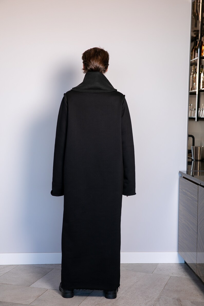 May include: A long black coat with a high collar and long sleeves. The coat is made of a soft, comfortable fabric and has a relaxed fit.