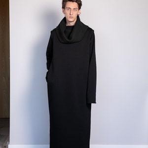 May include: A black long-sleeved turtleneck dress with a cowl neck. The dress is made of a soft, comfortable fabric and has a relaxed fit.