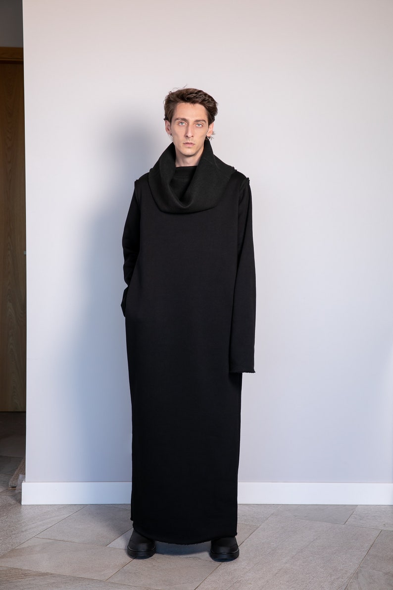 May include: A black long-sleeved turtleneck dress with a cowl neck. The dress is made of a soft, comfortable fabric and has a relaxed fit.