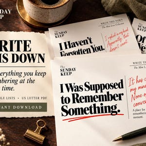 May include: A collection of white paper cards featuring black and red printed text including phrases like Write This Down, I Haven't Forgotten You, and I Was Supposed to Remember Something, accompanied by a gold metal binder clip and a pen.